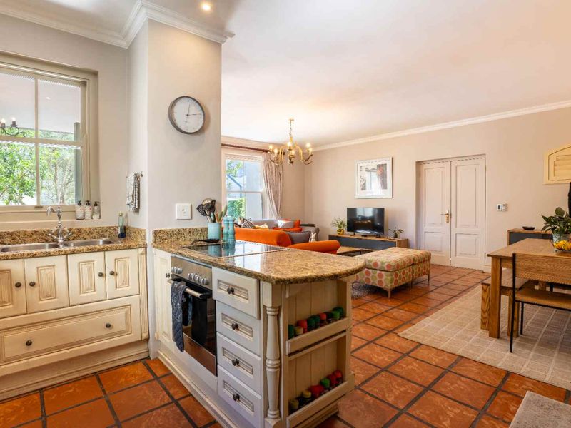 Spacious open-plan living area featuring a kitchen with granite countertops, built-in appliances, and classic terracotta floor tiles throughout.