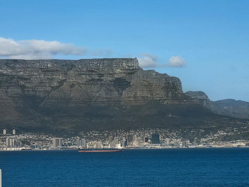 A scenic panoramic view of Table Mountain, the city skyline, and the ocean.