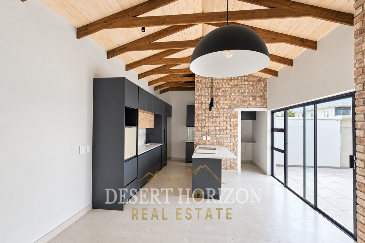 Modern kitchen featuring exposed timber trusses, a brick feature wall, sleek dark cabinetry, a central island, and large sliding doors opening to the patio.