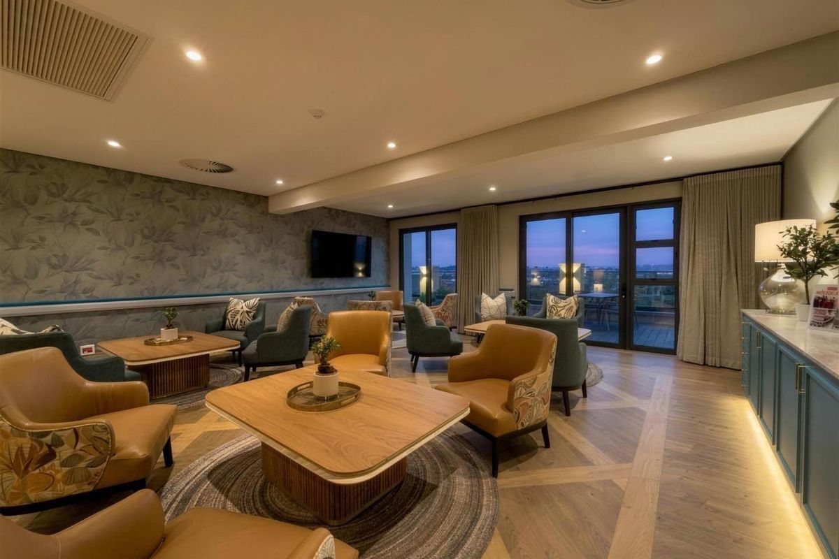 Spacious, well-appointed living area featuring elegant parquet flooring, recessed lighting, ducted air conditioning, and seamless access to an outdoor balcony.