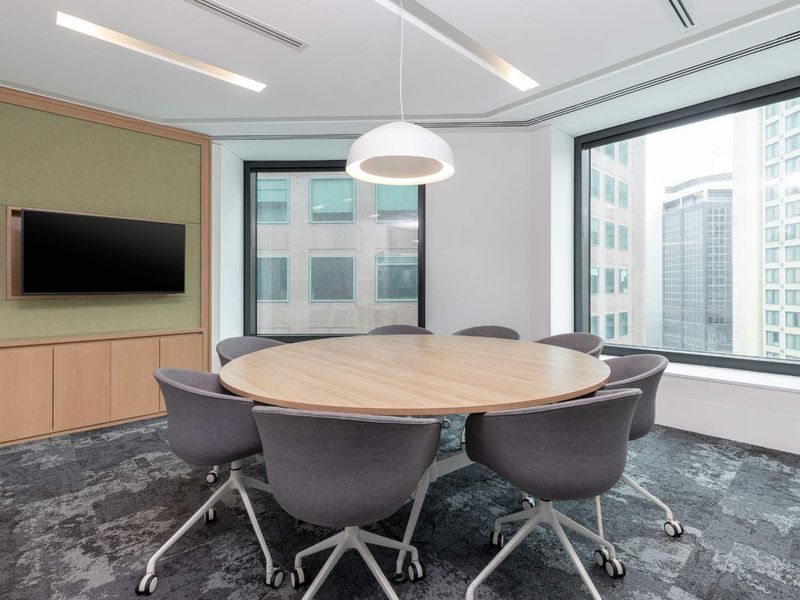 Modern professional meeting room featuring built-in cabinetry, large windows with city views, recessed lighting, and high-quality carpeted flooring.