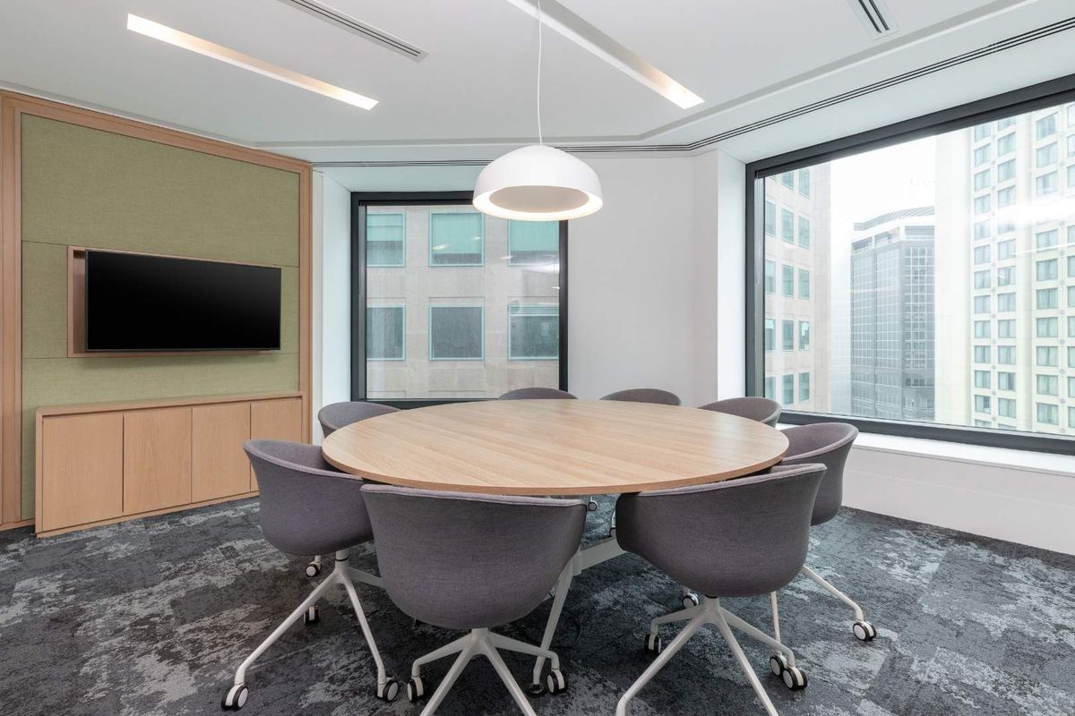 Modern professional meeting room featuring built-in cabinetry, large windows with city views, recessed lighting, and high-quality carpeted flooring.