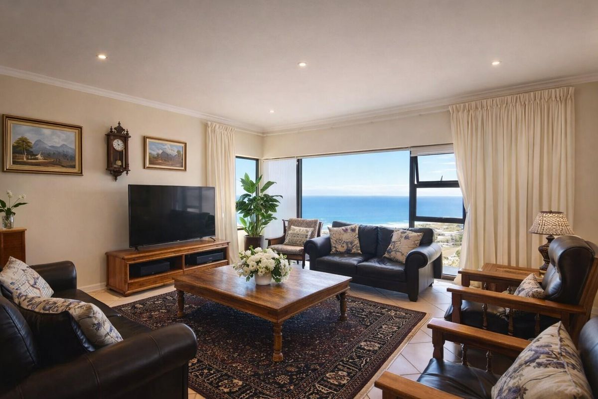 Spacious living room featuring large windows with expansive ocean views, recessed lighting, and neutral tiled flooring.