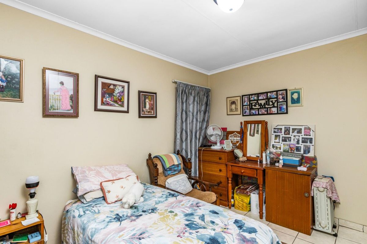 A standard bedroom featuring tiled flooring and neutral wall finishes, providing a functional living space.
