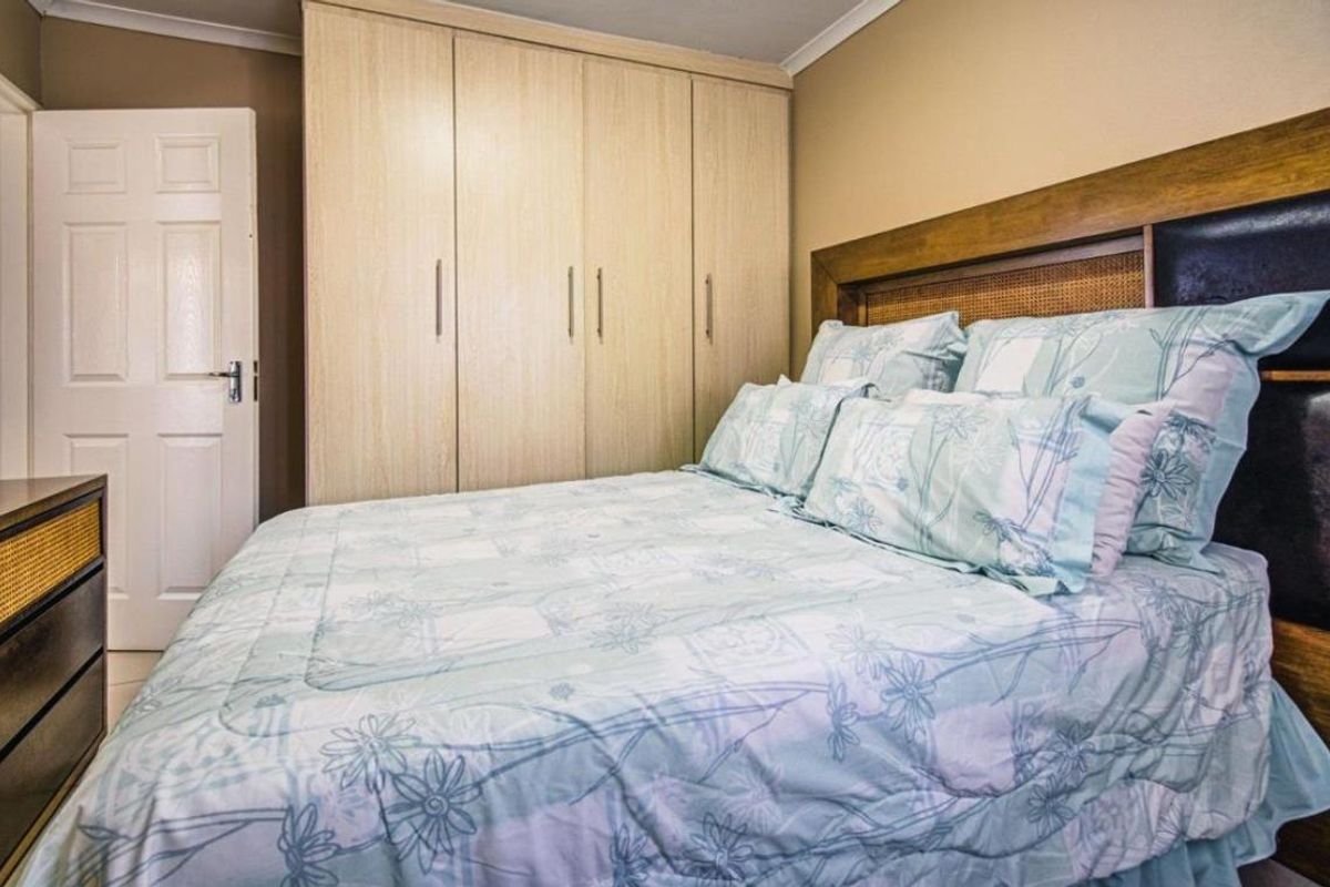 A well-maintained bedroom featuring built-in light wood cabinetry and a classic panel door.