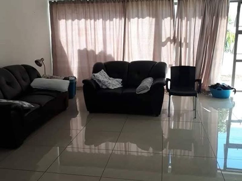 Spacious living room featuring large format polished floor tiles and a sliding glass door providing access to the exterior.