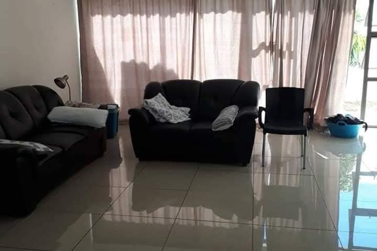 Spacious living room featuring large format polished floor tiles and a sliding glass door providing access to the exterior.