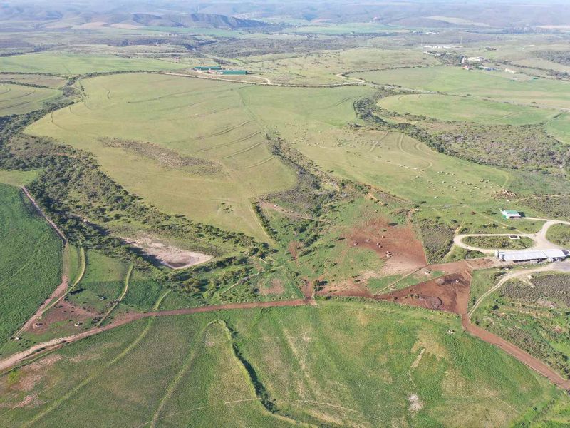 An expansive aerial view of the farm property, showcasing large grazing pastures, agricultural infrastructure, and established access roads across the landscape.