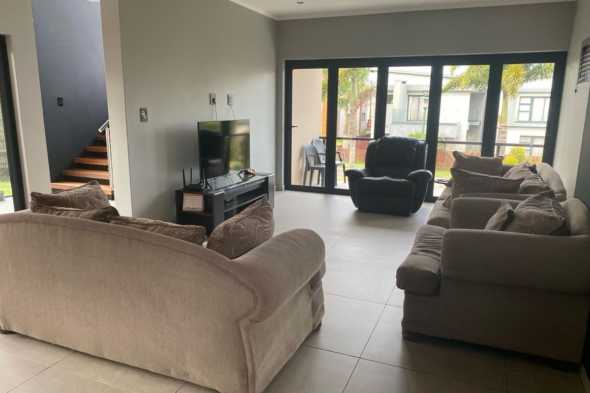 Spacious living room featuring large glass sliding doors that provide natural light and direct access to the outdoor patio area.