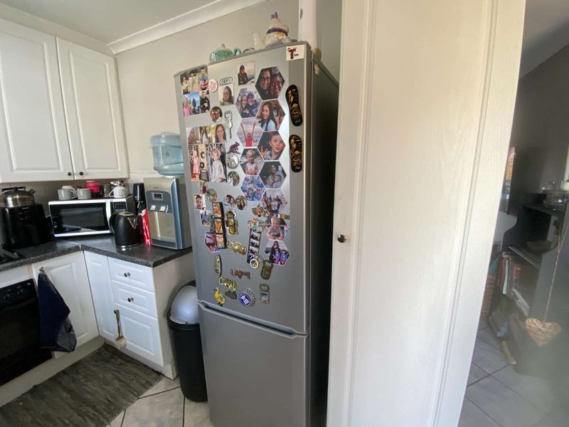 A functional kitchen area featuring white cabinetry, dark laminate countertops, and a built-in oven, providing a practical workspace for daily cooking.