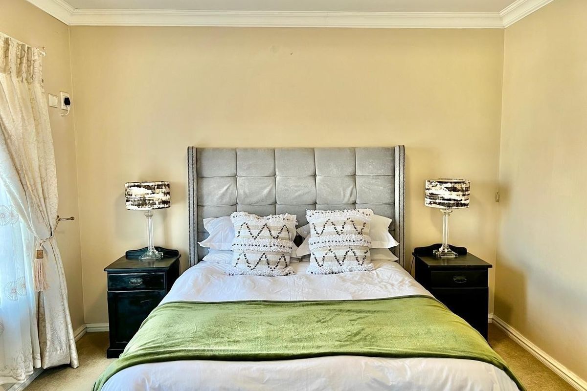 A well-proportioned bedroom featuring neutral wall tones, coving, and carpeted flooring, providing a comfortable and functional living space.