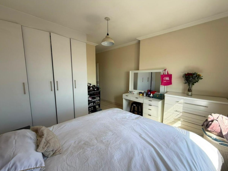 A functional bedroom featuring ample built-in cupboard storage and neutral wall finishes, providing a comfortable and practical living space.