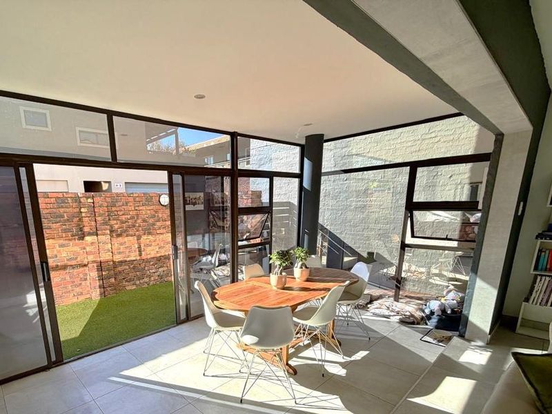 Bright open-plan living area featuring large glass sliding doors that provide seamless access to the rear patio and garden.
