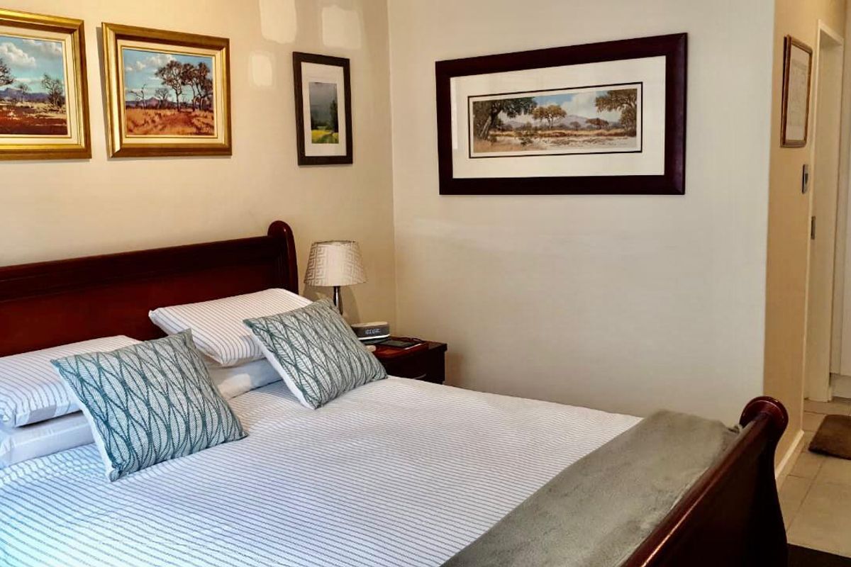 A cozy bedroom featuring tiled flooring and neutral wall finishes, providing a comfortable and functional sleeping space.