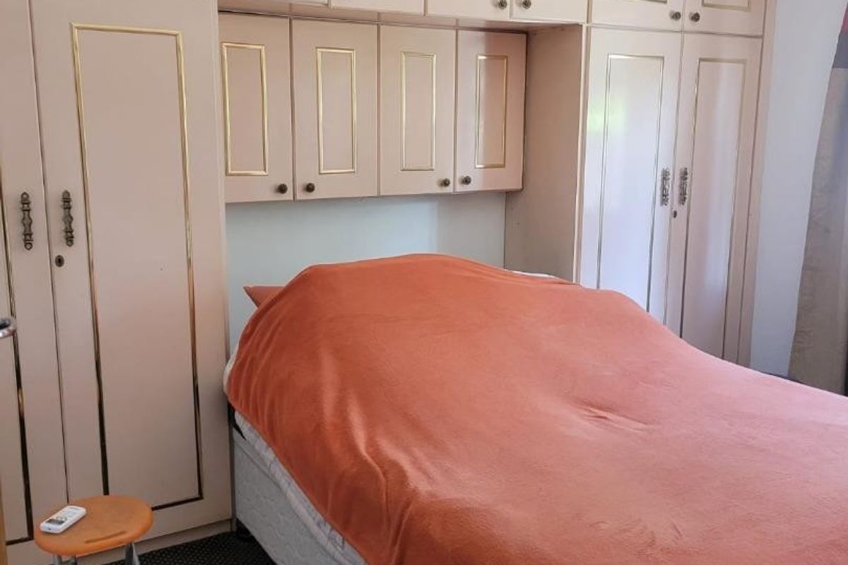 A bedroom featuring extensive built-in cabinetry and wardrobe storage surrounding the bed area.