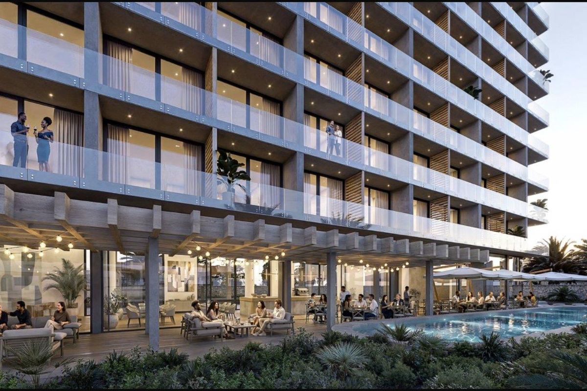 Modern apartment building exterior featuring a swimming pool, covered timber pergola deck, and glass-fronted balconies for residents.