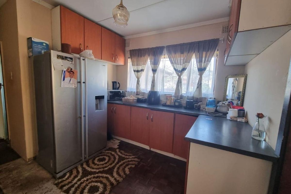 A functional kitchen featuring laminate cabinetry and countertops, offering a practical layout with potential for modernization and cosmetic updates.