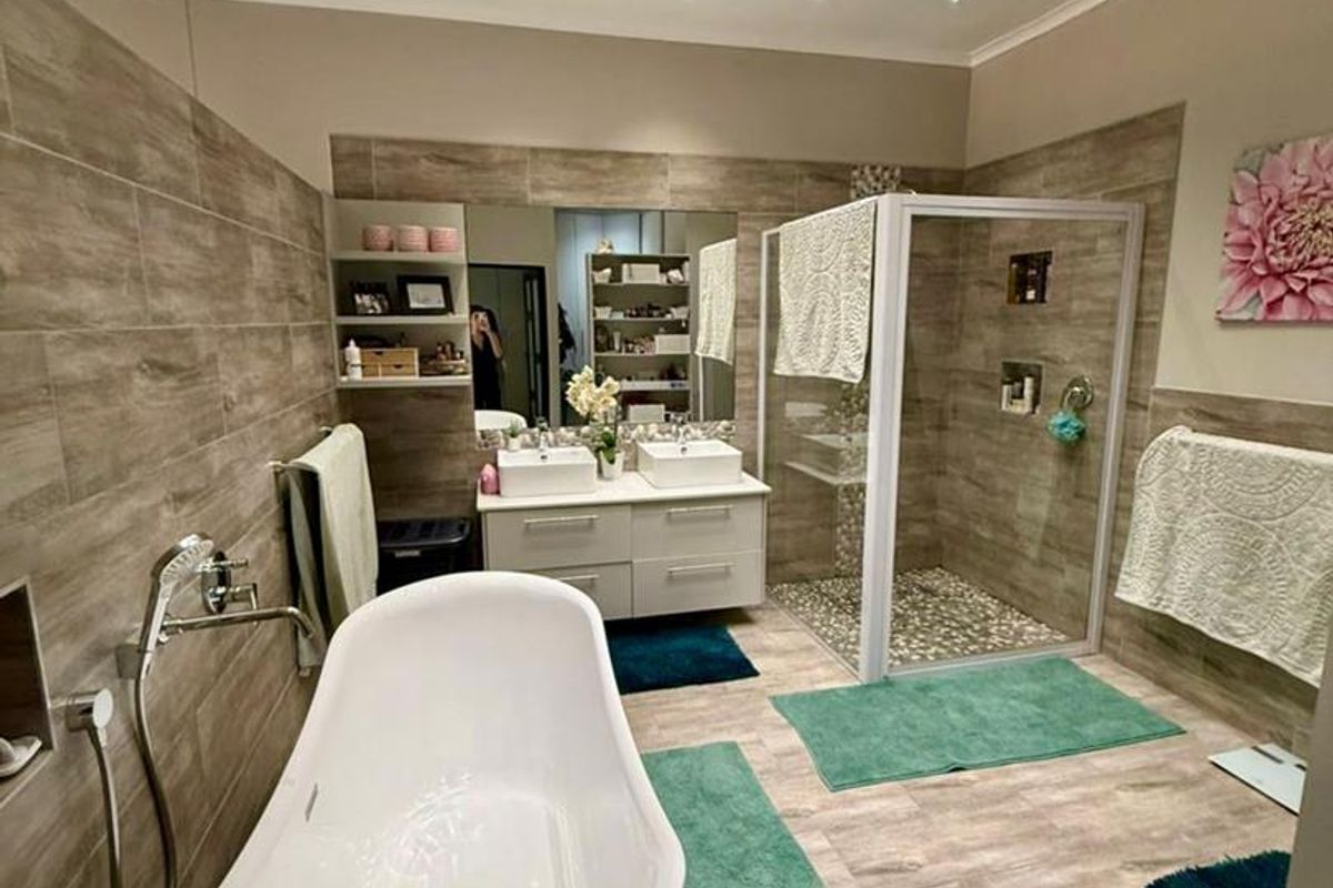 Modern bathroom featuring a freestanding bathtub, a glass-enclosed walk-in shower, and a double vanity with integrated sinks and recessed ceiling lighting.