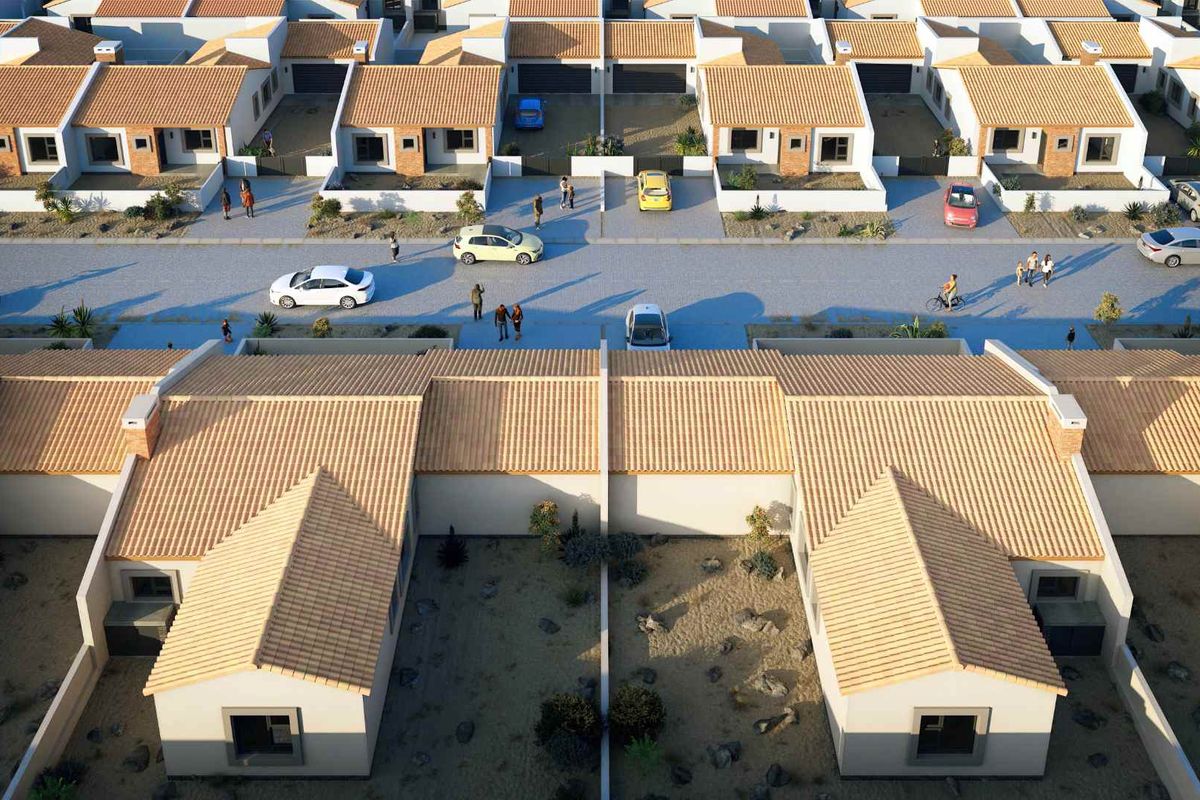 Aerial view of a residential housing development featuring uniform single-story homes with tiled roofs and private rear garden spaces.
