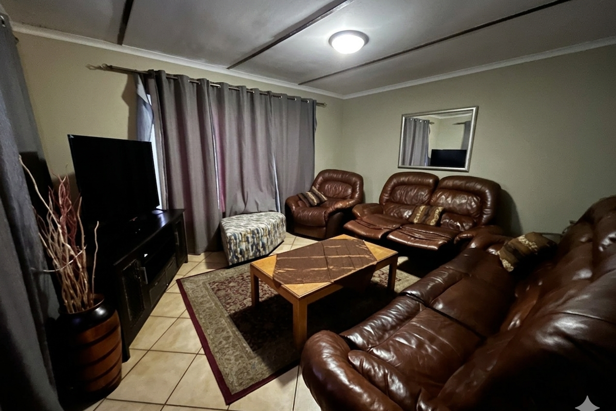 A living room featuring tiled flooring and a ceiling with visible panel joints, providing a functional and comfortable space for relaxation.