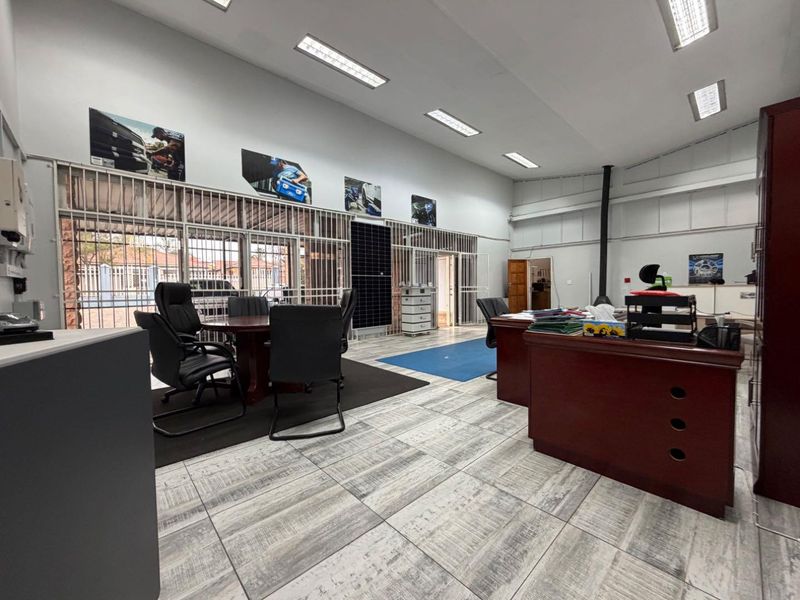 Spacious commercial office area featuring tiled flooring, recessed lighting, security bars on windows, and a built-in wood burning stove.