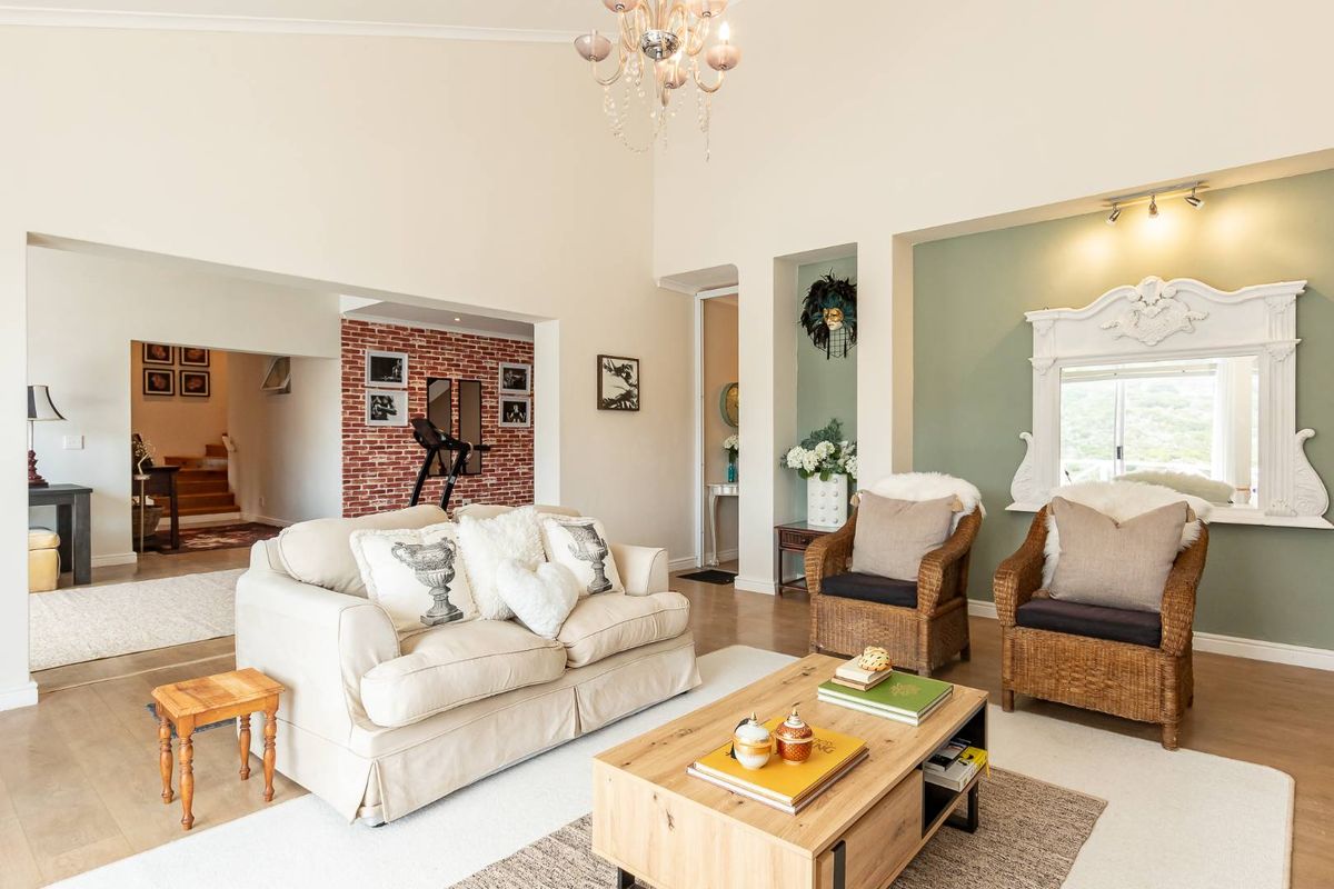 Spacious living room featuring a vaulted ceiling, exposed brick accent wall, and elegant recessed niches, creating a bright and inviting atmosphere.