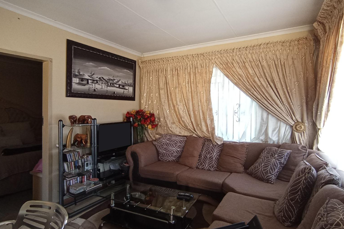 A cozy living room featuring neutral wall finishes, coved ceilings, and large window treatments, providing a comfortable and functional space.