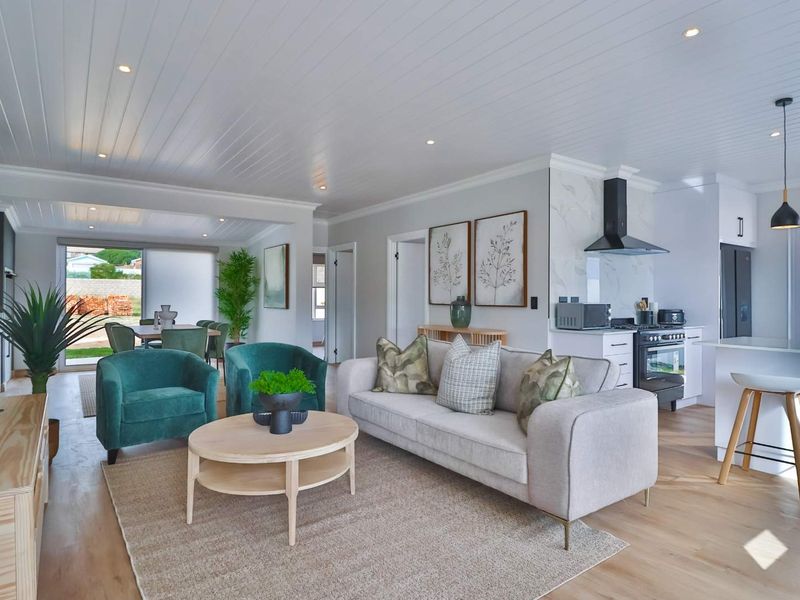 Modern open-plan living area featuring a contemporary kitchen with marble-look splashback, gas stove, and seamless flow to the dining space and outdoor patio.