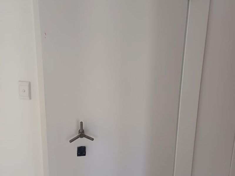 A secure utility room or vault featuring a heavy-duty reinforced door with an electronic keypad lock and integrated fire safety alarm.
