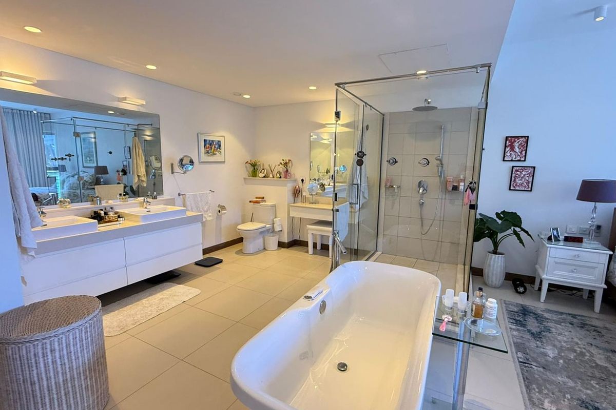 Spacious modern bathroom featuring a double vanity, a glass-enclosed walk-in shower, and a freestanding bathtub with contemporary fixtures and recessed lighting.
