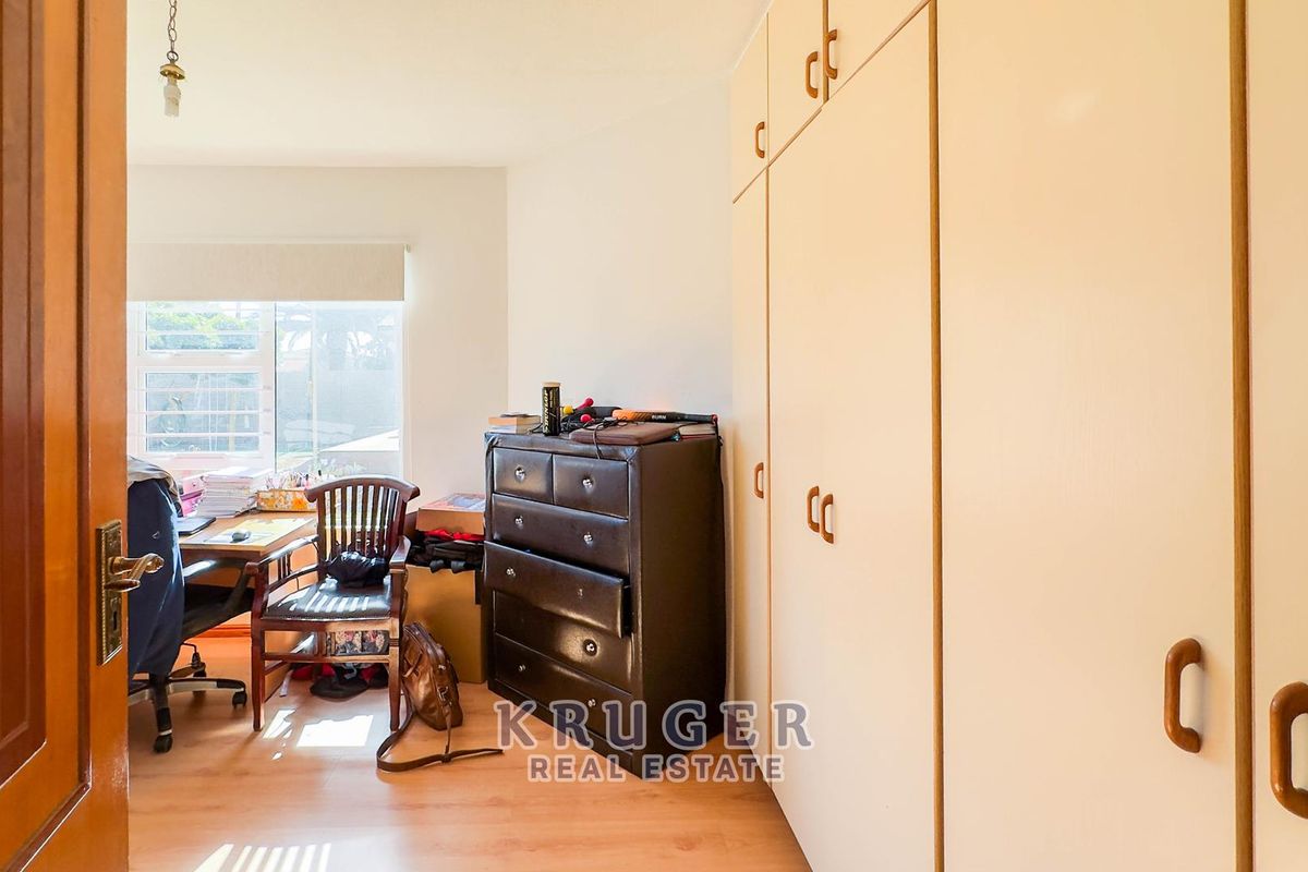 A bedroom featuring built-in floor-to-ceiling cabinetry and laminate flooring, providing ample storage space and natural light.