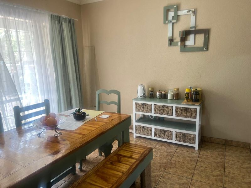 A dining area featuring ceramic tile flooring and a sliding glass door providing natural light.