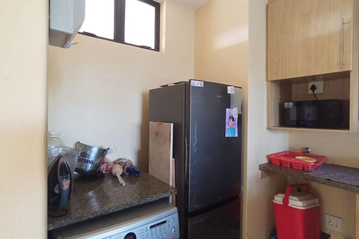 A functional kitchen area featuring granite countertops, built-in cabinetry, and dedicated space for appliances.