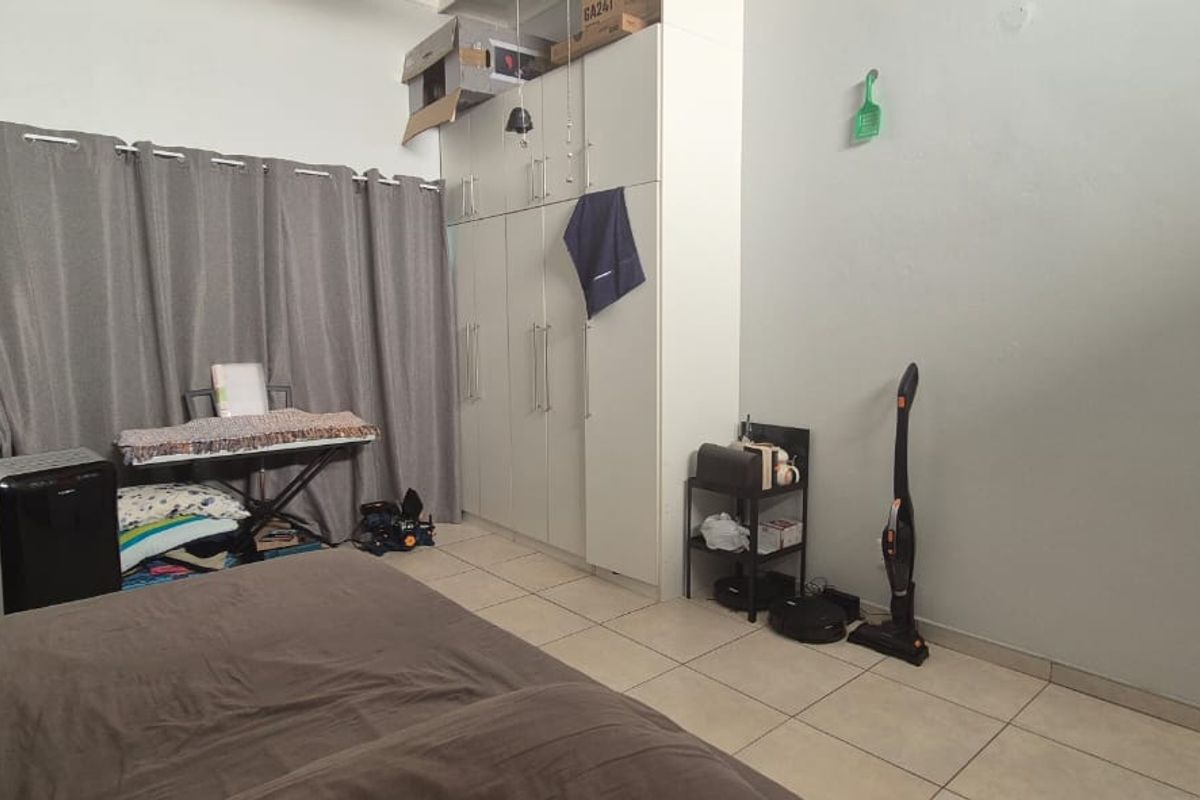A bedroom featuring built-in floor-to-ceiling cabinetry and tiled flooring, offering functional storage space.