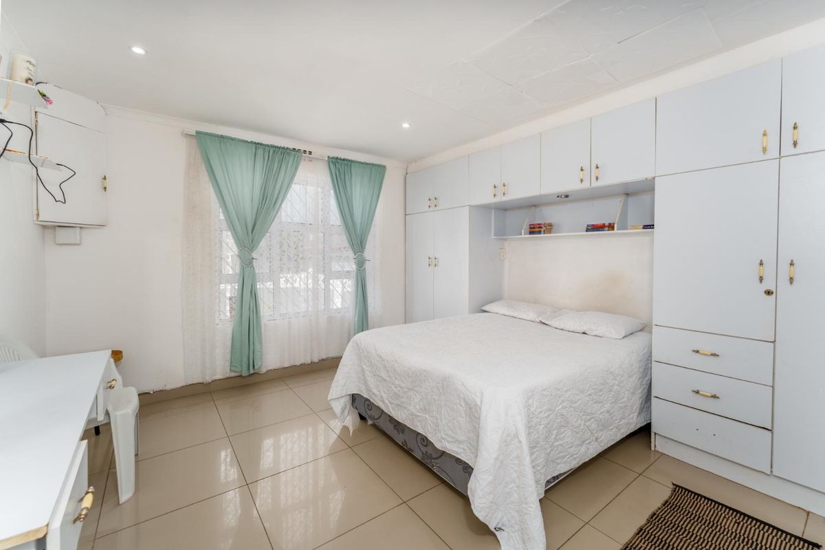 A bedroom featuring built-in floor-to-ceiling cabinetry, tiled flooring, and recessed ceiling lighting.