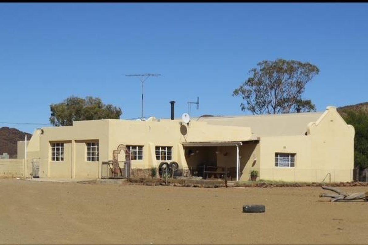 A view of the rear exterior of a farm-style dwelling featuring a covered patio area and traditional architectural detailing.