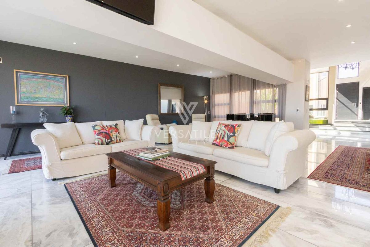 Spacious living room featuring polished marble flooring, recessed ceiling lighting, and a modern dark accent wall.