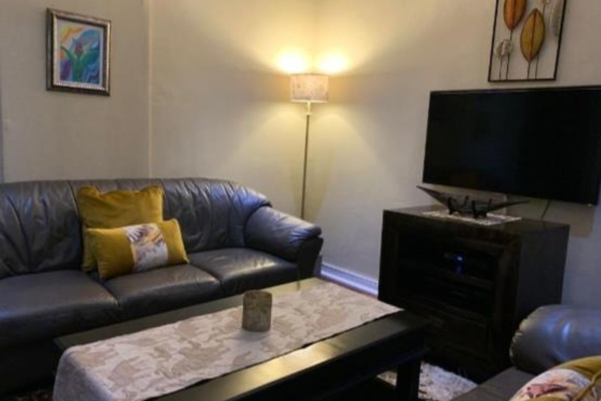 A cozy living room area featuring neutral wall finishes and standard residential lighting.