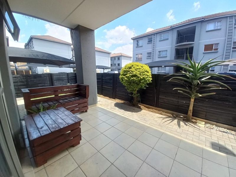 A covered patio area featuring tiled flooring and timber perimeter fencing, providing a private outdoor space for relaxation.