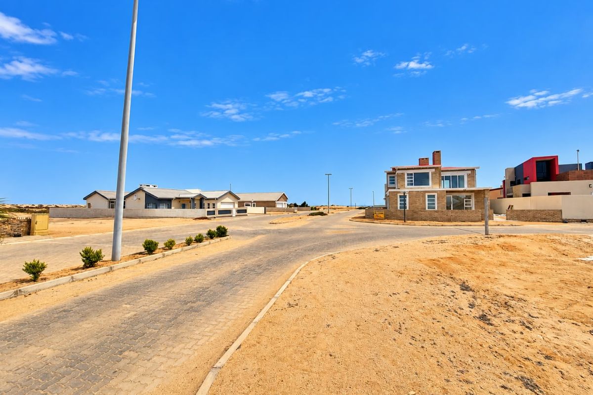 A view of the paved street and surrounding residential neighbourhood in a coastal estate setting.