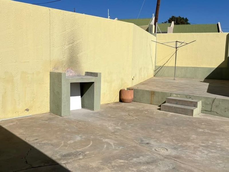 A private rear courtyard featuring a built-in braai, concrete patio area, and perimeter walling, offering a blank canvas for outdoor entertainment.