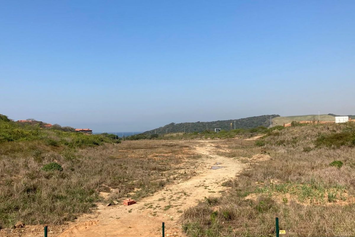 An undeveloped plot of land featuring natural vegetation and perimeter fencing, offering potential for future residential development.