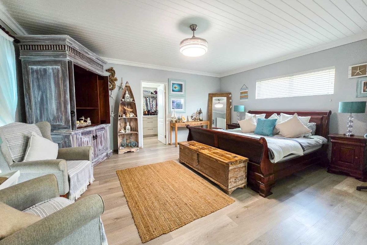 Spacious bedroom featuring light wood-look flooring, a white tongue-and-groove ceiling, and an adjoining walk-in closet.