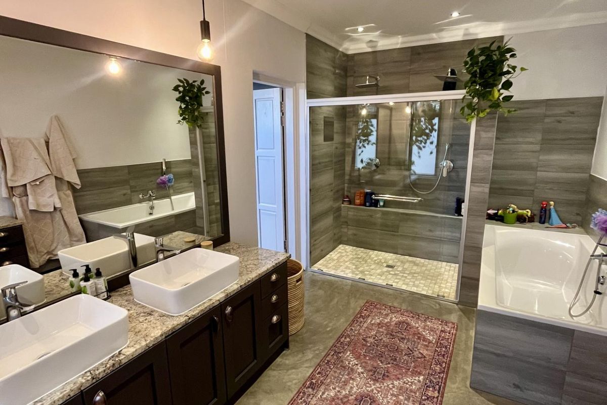 Modern bathroom featuring a double vanity with granite countertops, vessel sinks, a spacious walk-in shower with glass enclosure, and a separate built-in bathtub.