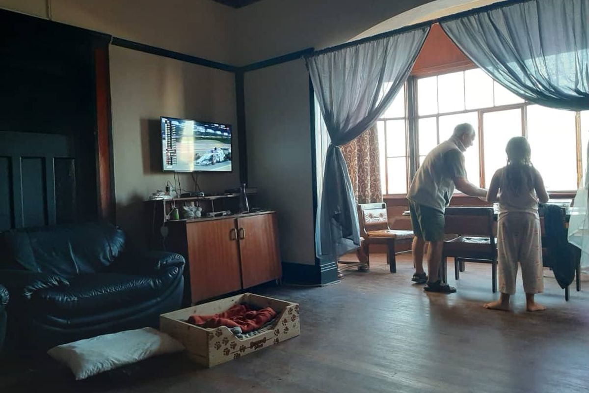Spacious living room featuring original timber flooring, large windows with natural light, and classic architectural details including picture rails and timber trim.