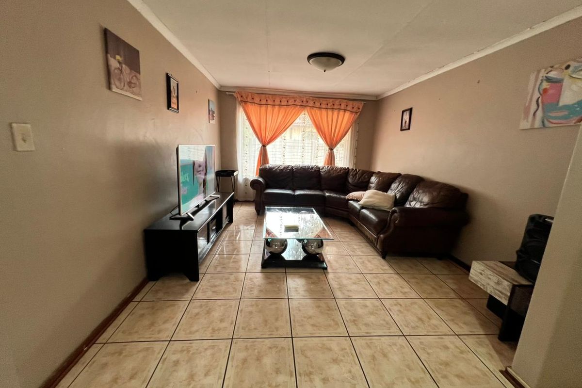 A living room featuring ceramic floor tiles and neutral wall tones, providing a functional space for relaxation.