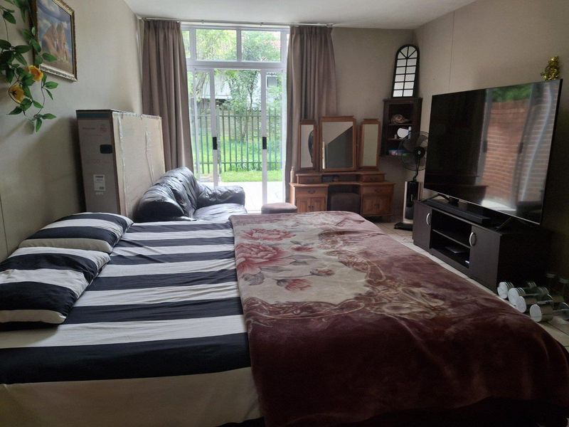 A bedroom featuring tiled flooring and a sliding glass door providing access to the exterior.