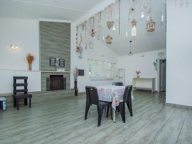 Spacious living room featuring a tiled fireplace surround, vaulted ceilings, and wood-look tiled flooring, offering a bright and open living area.