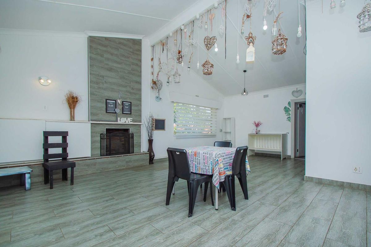 Spacious living room featuring a tiled fireplace surround, vaulted ceilings, and wood-look tiled flooring, offering a bright and open living area.