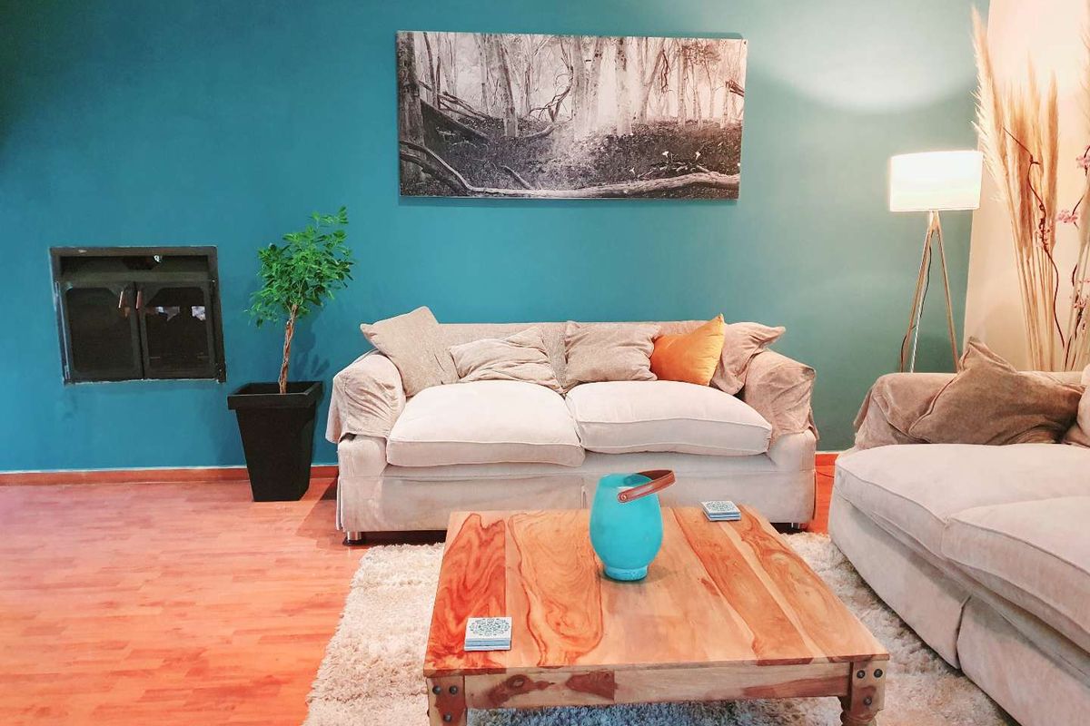 A cozy living room featuring a built-in fireplace and warm-toned laminate flooring, creating a comfortable and inviting atmosphere.